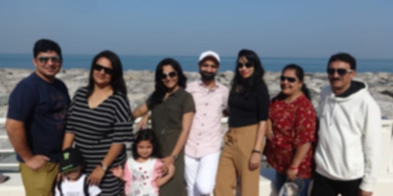 A family posing for a picture with the beach as a backdrop