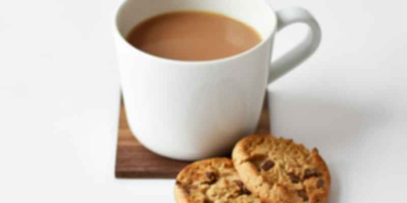 A cup of tea with 2 biscuits