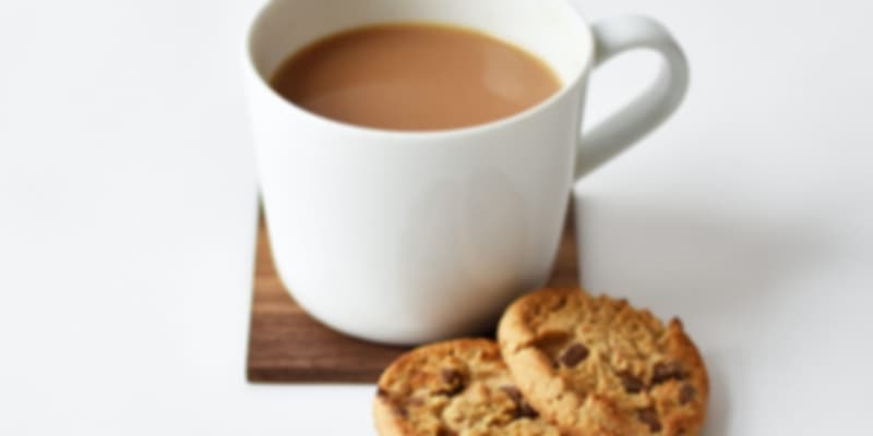 A cup of tea with 2 biscuits