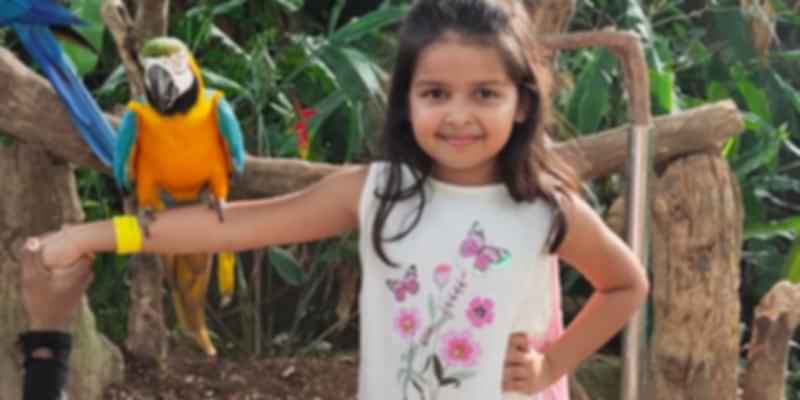 Little one posing with the parrot during our family vacation to Singapore