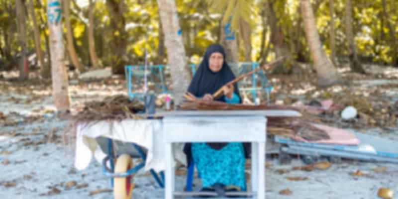 Maldives woman weaving handicrafts