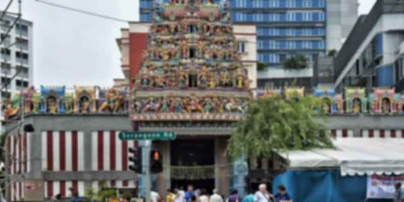 Colorful facade of Sri Veeramakaliamman Temple in Little India, Singapore, with intricate sculptures and a bustling crowd at the entrance.