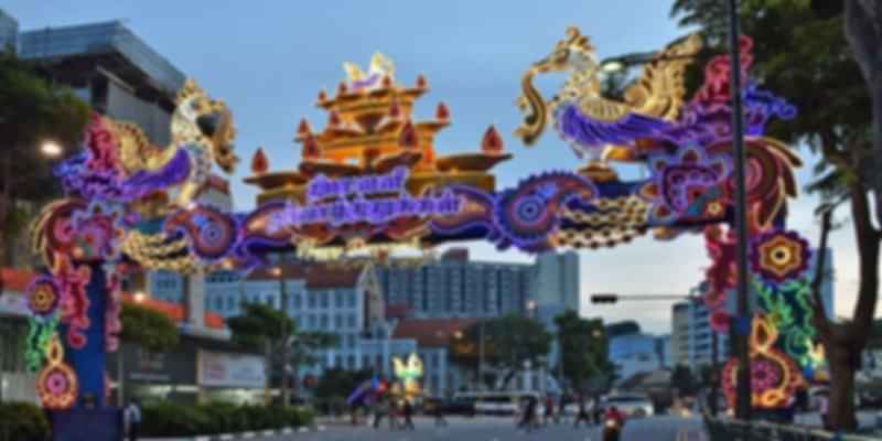 Festive street arch in Little India, Singapore, lit up with bright lights and decorative figures during Deepavali celebrations.