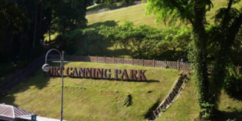 Entrance signage of Fort Canning Park on a grassy slope, a historic hilltop park in the heart of Singapore