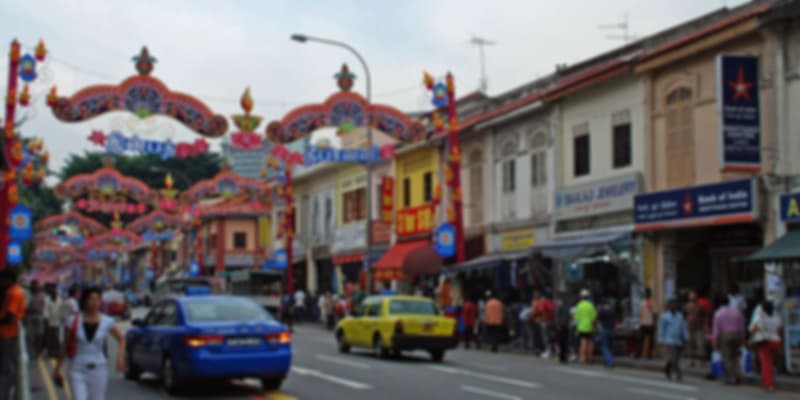 Vibrant street market scene in Little India, Singapore, with colorful decorations, bustling crowds, and traditional Indian shops during festive season.