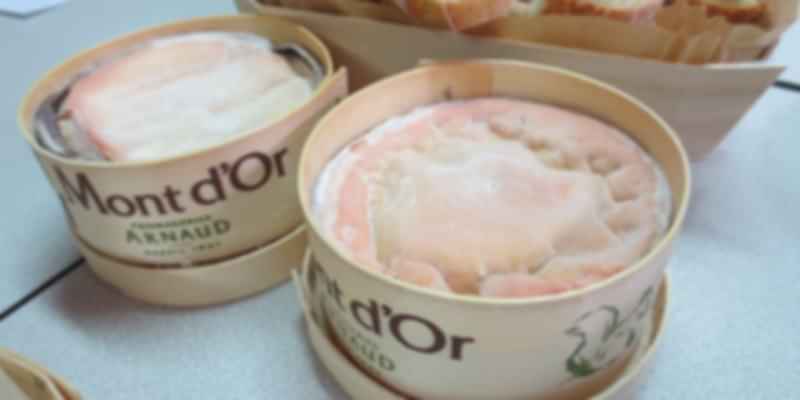 Vacherin Mont D'Or cheese in round wooden boxes, a creamy seasonal Swiss delicacy often eaten melted with bread or potatoes.