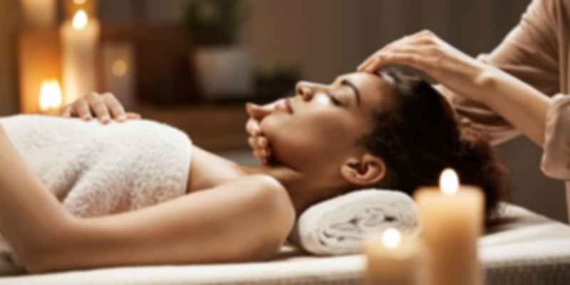 Woman receiving a relaxing head massage in a spa-like setting, symbolizing Varanasi’s blend of spiritual healing and traditional Ayurvedic wellness therapies.