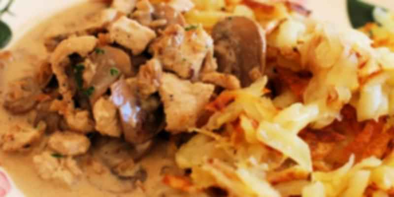 Zürcher Geschnetzeltes served with crispy rösti, featuring veal in creamy mushroom sauce—a classic Zurich specialty.