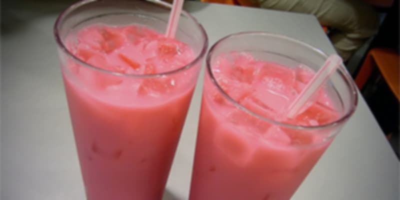 Pink rose-flavored Bandung drink served in clear plastic cups with straws.