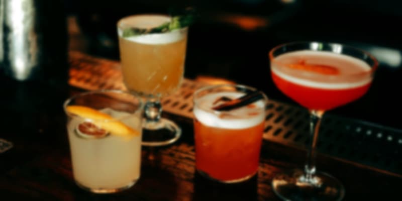 Assorted Singaporean craft cocktails displayed on a bar counter with vibrant colors.