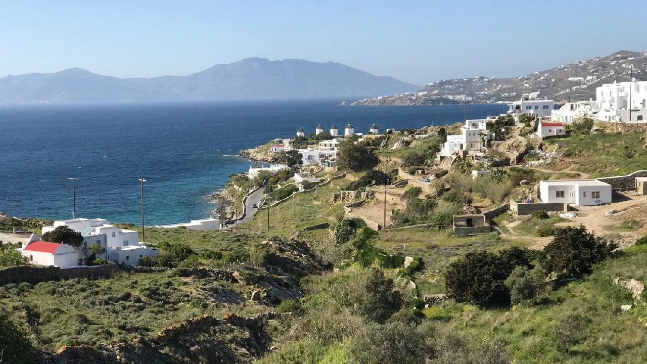 Mykonos beaches with golden sand, turquoise Aegean water, and white Cycladic buildings