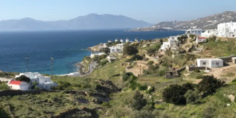 Mykonos beaches with golden sand, turquoise Aegean water, and white Cycladic buildings