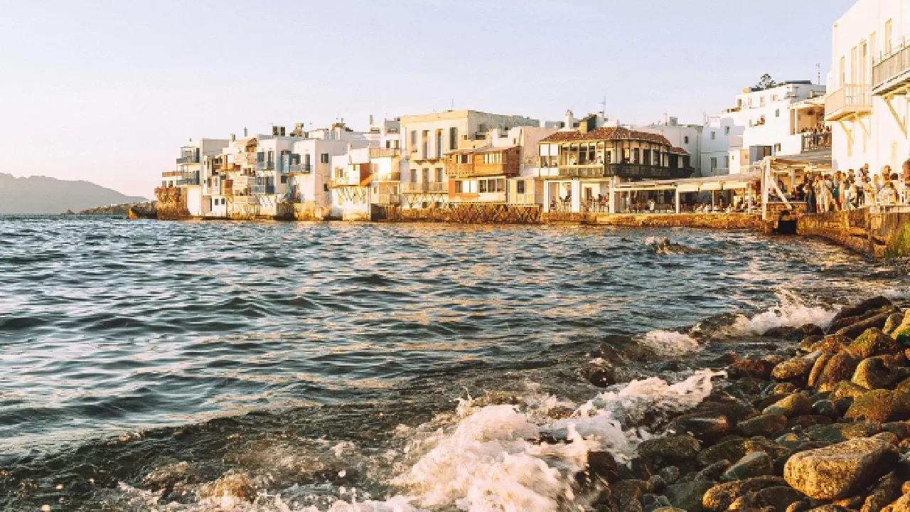 Popular party beaches in Mykonos with beach clubs, DJs, and crowds by the Aegean Sea