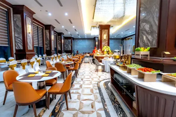 Elegant dining hall of Martabaan by Hemant Oberoi, one of the finest Indian restaurants in Abu Dhabi, featuring luxurious interiors, comfortable seating, and a premium buffet setup.