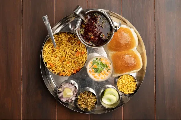 Traditional Gujarati thali with pav, curry, farsan, and sev served at Rasoi Ghar